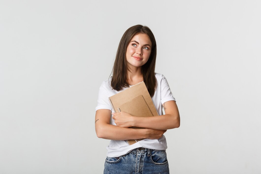 portrait-smiling-nostalgic-female-student-looking-upper-left-corner-holding-notebooks_1258-19148